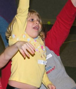 A young girl raising her hand